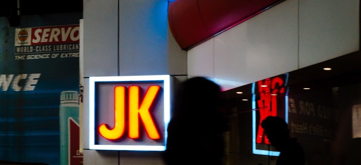 Glowing jk sign outside a building at night